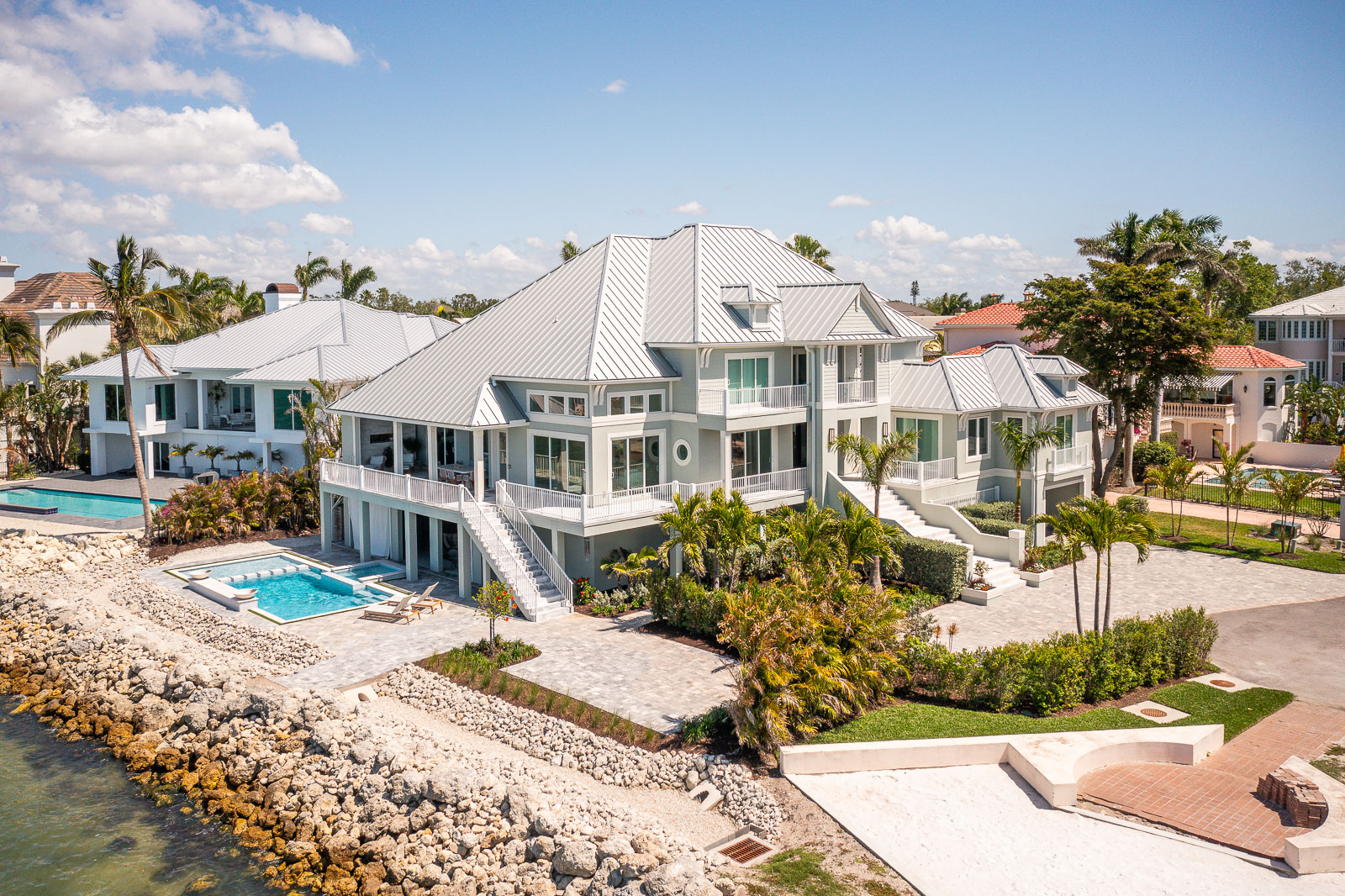 Aerial view of a complete waterfront landscape transformation with pool, patio, and planting beds