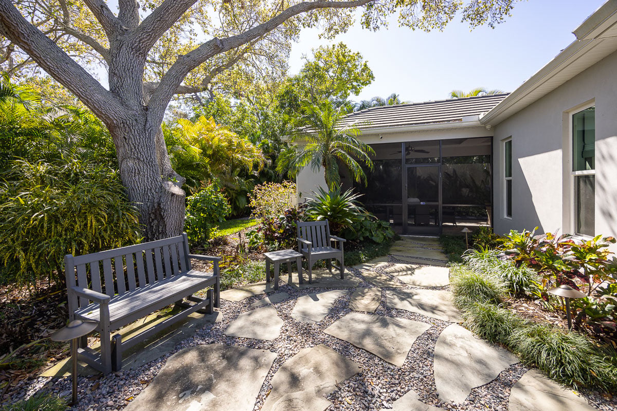 A waterfront Florida home with a maintained lawn and established palms