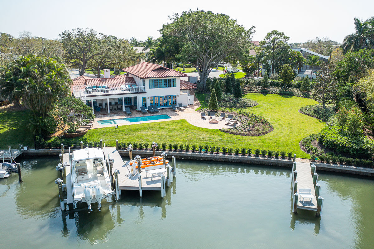 A waterfront Florida home with a maintained lawn and established palms