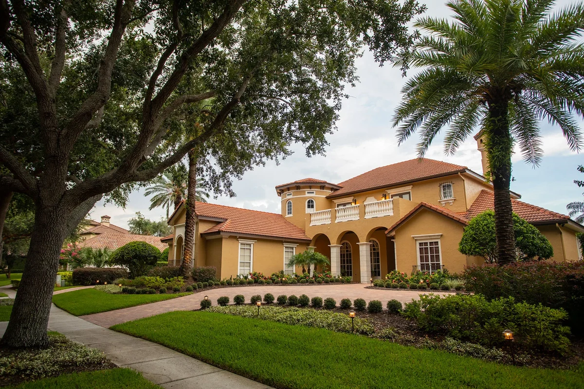A front-facing view of a Florida home framed by a professionally redesigned landscape