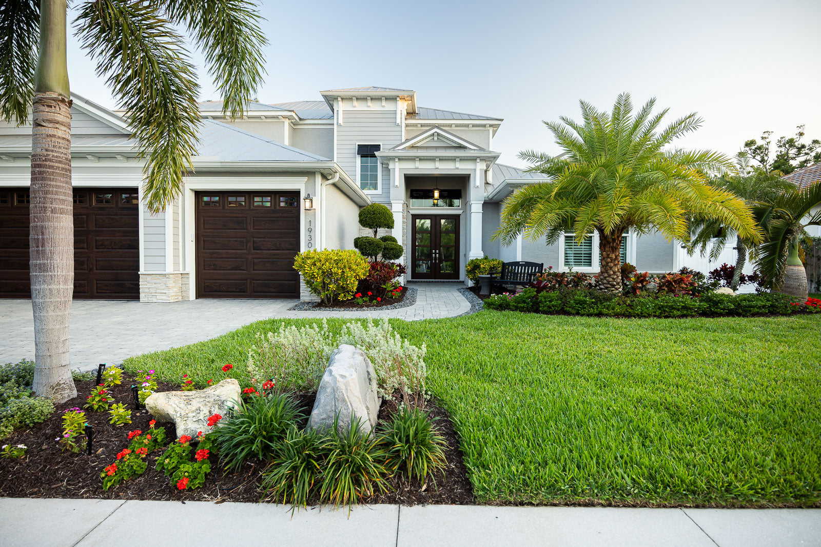 Renewed front-yard landscape beds bordering a green lawn in Indian Harbour Beach