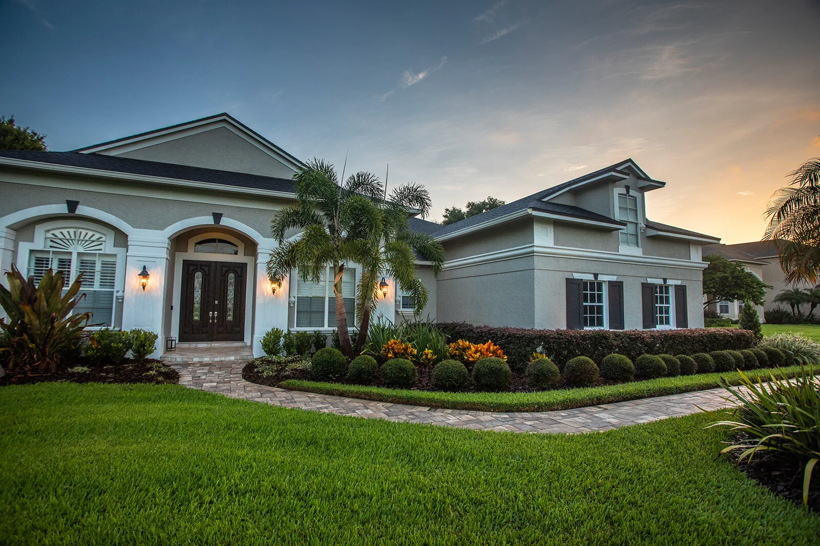 A refined Florida home surrounded by a professionally redesigned tropical landscape at sunset